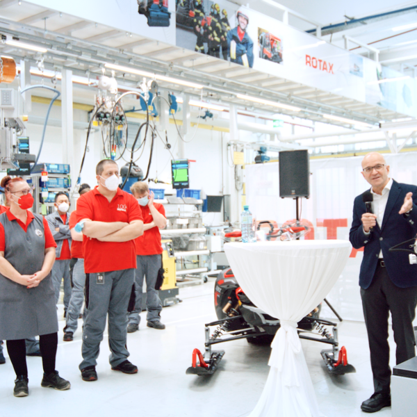 Mitarbeiter:innen lauschen einer Rede von José Boisjoli in der Produktionshalle am Standort in Gunskirchen