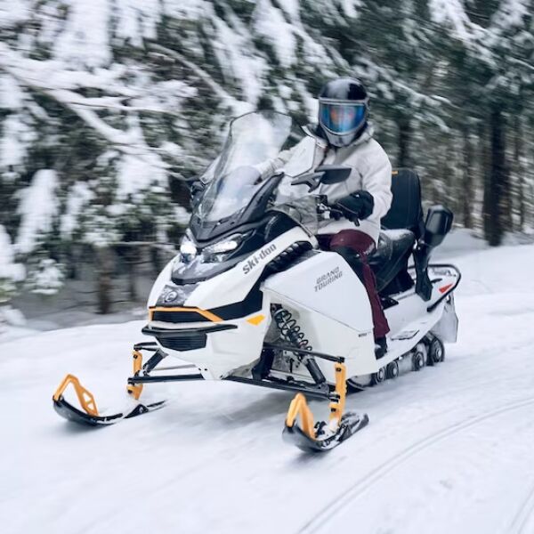 Skidoo driving through winter woods